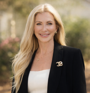 Smiling woman in a black blazer outside.